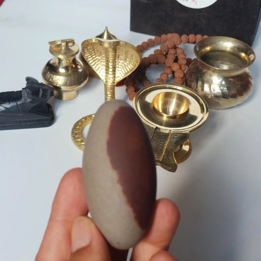 Natural Shiva Lingam stone with brass puja accessories and Rudraksha beads