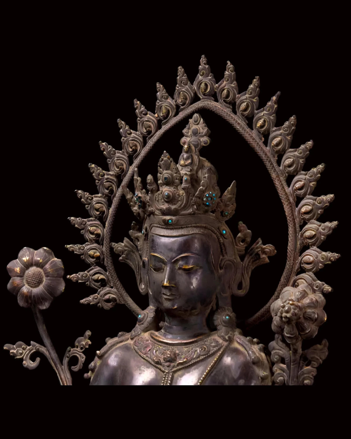 Intricately carved silver Buddhist deity statue with ornate halo and crown