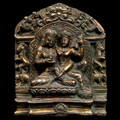 Bronze plaque with two figures in a decorative frame on a black background