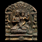 Bronze plaque with two figures in a decorative frame on a black background