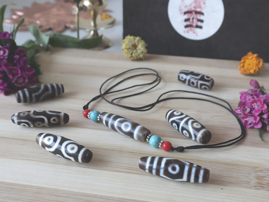 Handcrafted brown and white patterned stone beads on a black necklace cord