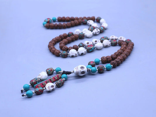 Handmade Rudraksha mala with turquoise beads, white skull accents, and mantra plaque.