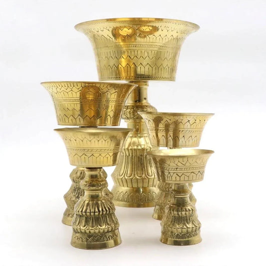 Set of five engraved brass puja bowls and pedestals