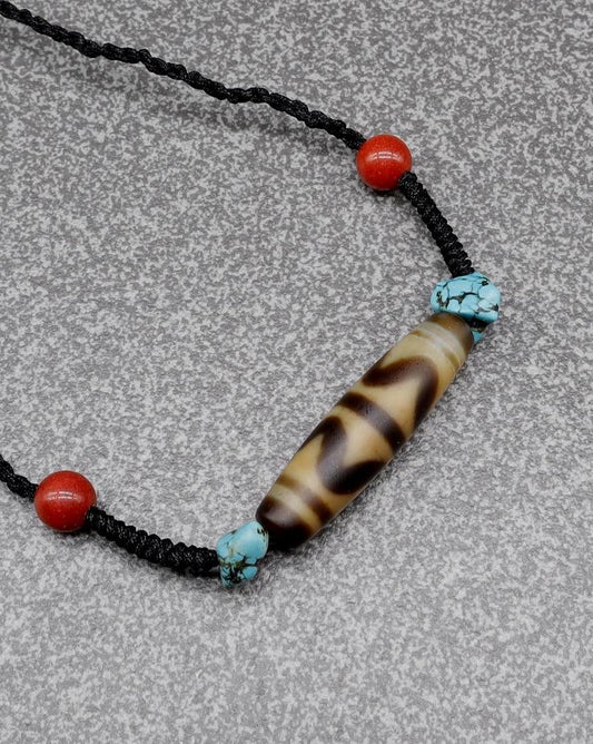 Handmade spiritual necklace with a striped agate bead, turquoise accents, and red beads.