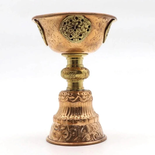 Handcrafted brass incense burner with traditional ornate carvings and a perforated lid.