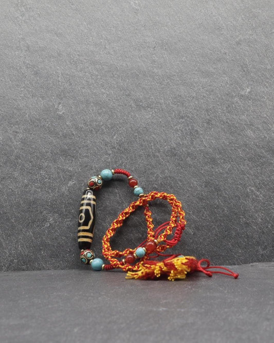 Handcrafted red cord bracelet with turquoise beads and a carved black bone bead