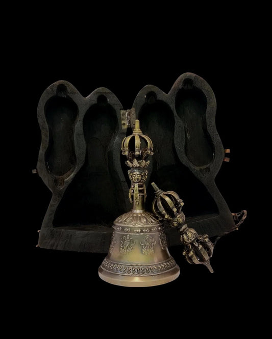 Ornate Tibetan ritual bell and vajra set against a dark background