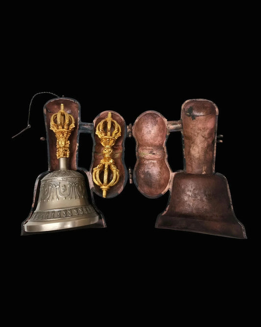 Traditional brass ritual bell with ornate golden handle and protective case