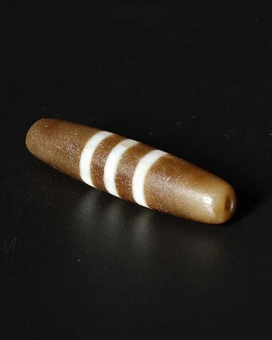 Brown cylindrical spiritual bead with three white stripes