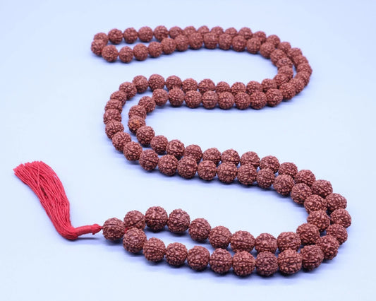 Authentic Rudraksha bead mala with a red tassel on a light background