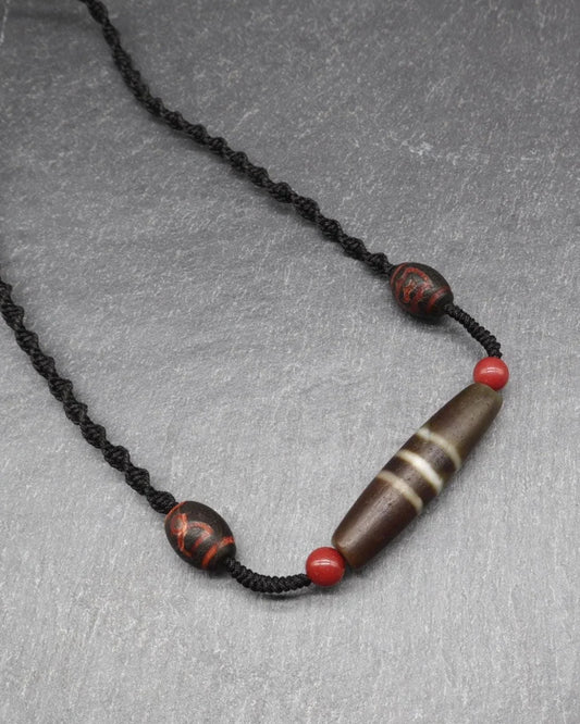 Handmade spiritual necklace with brown striped bead and red accent beads on a black cord